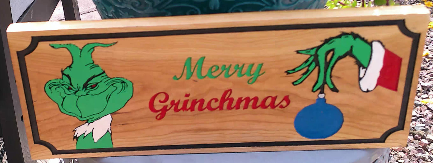 Wooden sign with Grinch-themed design and 'Merry Grinchmas' text.