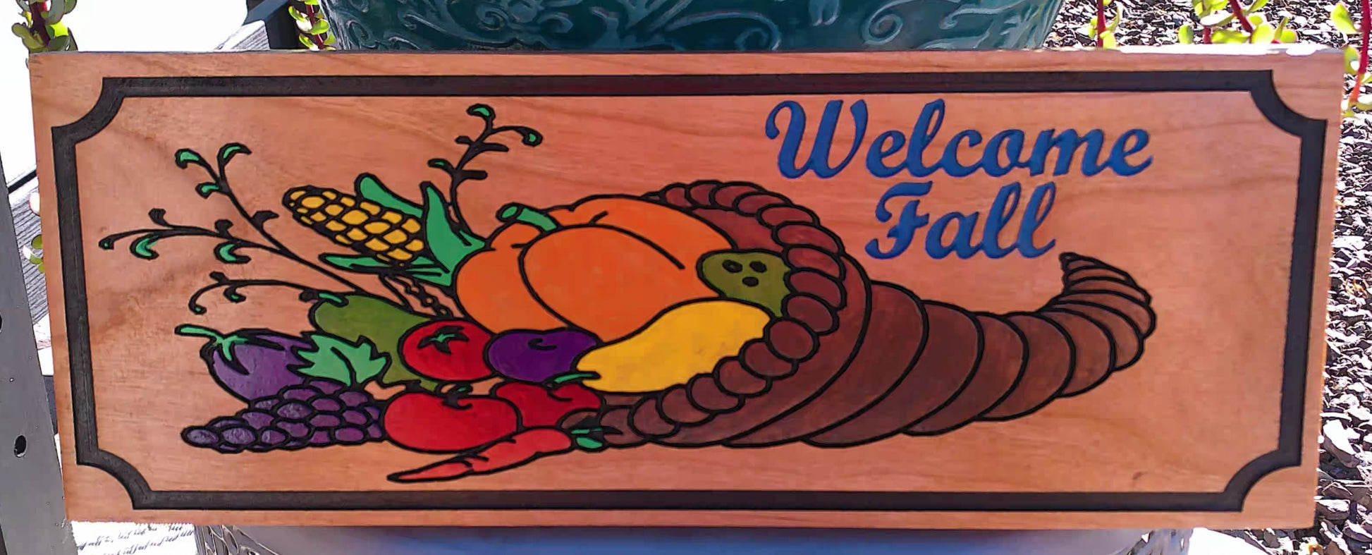 Wooden sign with autumn-themed decorations and 'Welcome Fall' text.