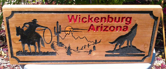 Wooden sign with engraved images and 'Wickenburg Arizona' text