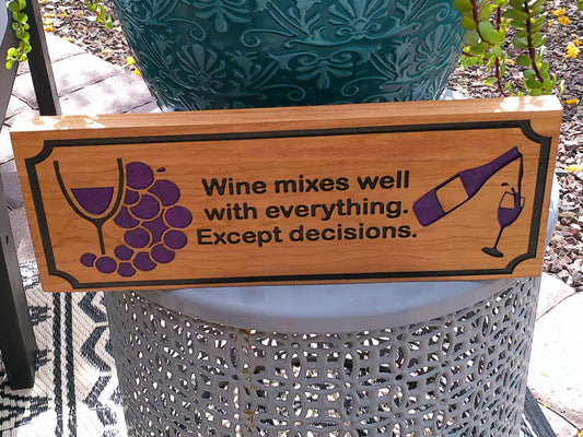 Wooden sign with wine-themed text and graphics on a decorative plant stand.