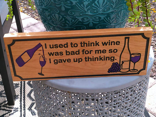 Wooden sign with wine-themed design and humorous quote on a decorative chair.
